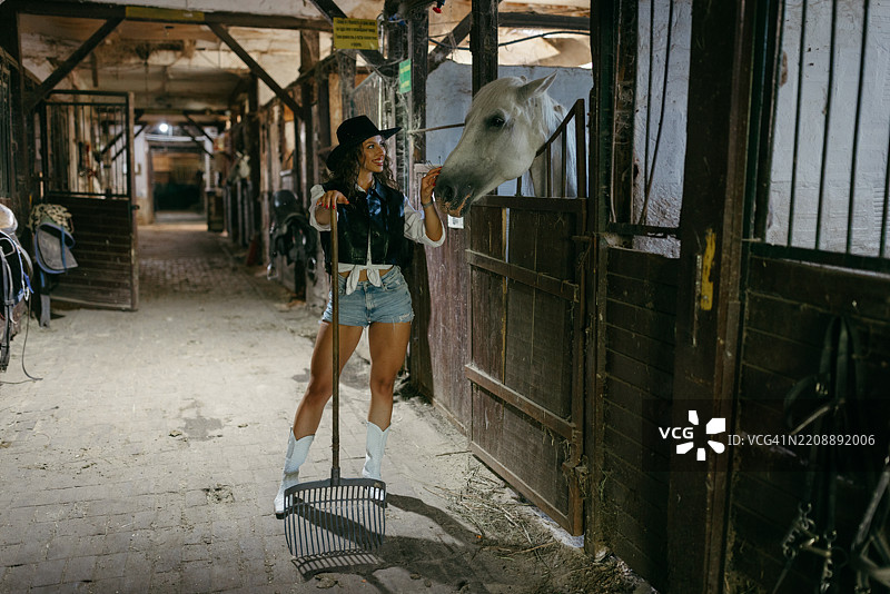 牛仔女孩在马厩中的温柔时刻图片素材