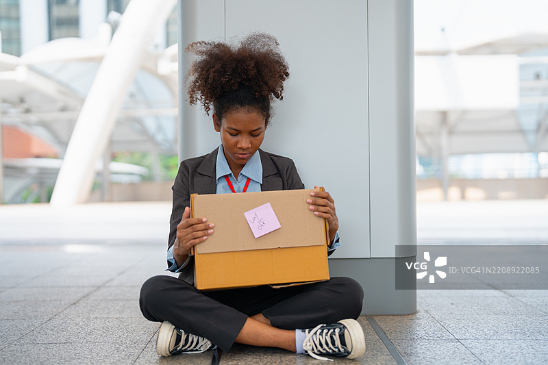 一位年轻的女商人在离开工作后走出办公室。图片素材