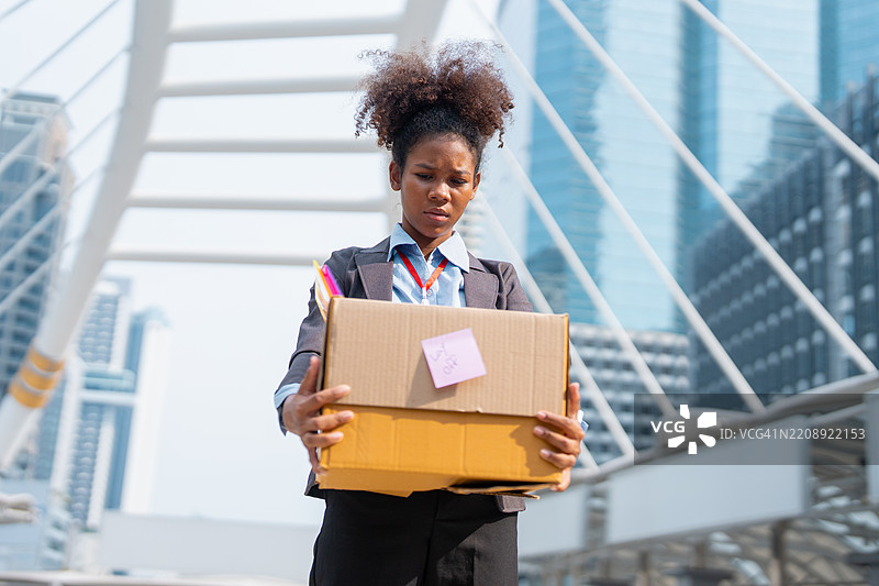 商业概念失败。一位女商人坐在台阶上，感到沮丧和严肃。图片素材