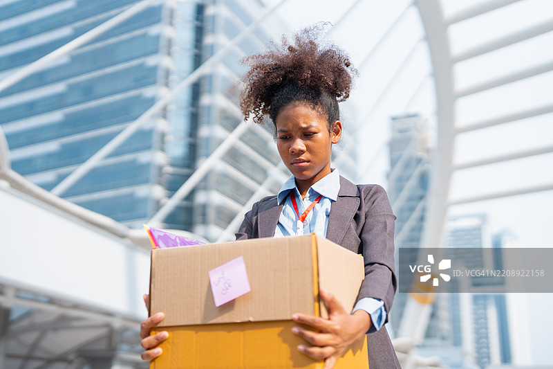 一位年轻的女商人在离开工作后走出办公室。图片素材