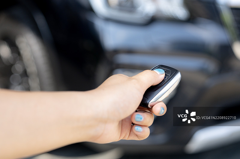手按下汽车遥控器上的解锁键图片素材