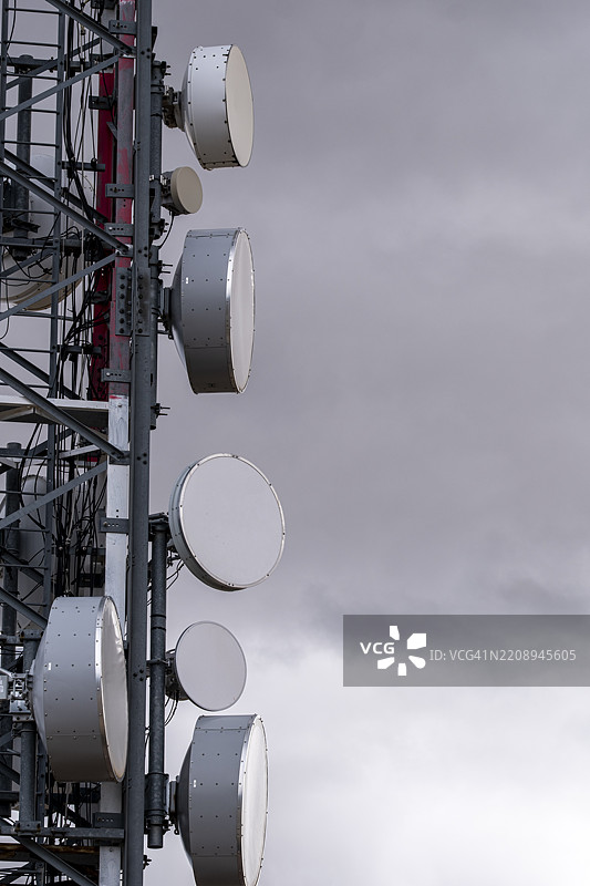 灰色天空下的通信塔与卫星天线图片素材