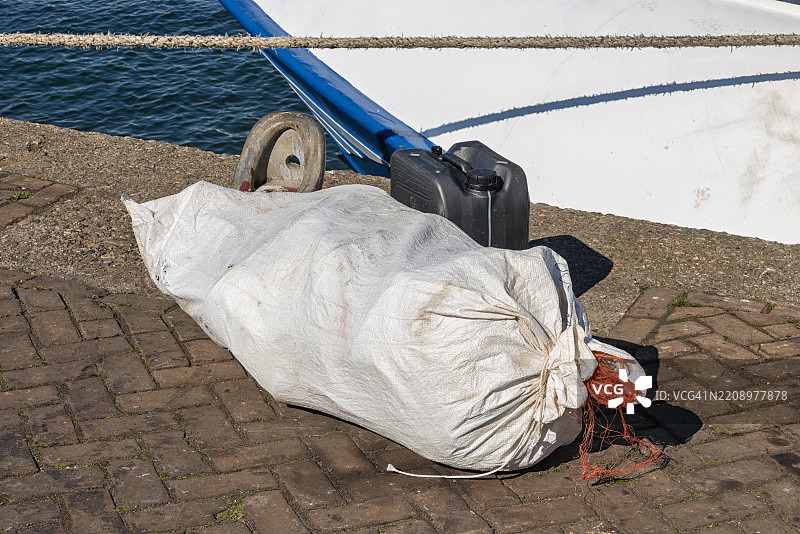 浓密的白色黄麻袋躺在码头的港口外面图片素材