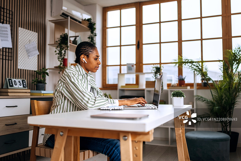 年轻的自由职业者在家中使用笔记本电脑工作图片素材