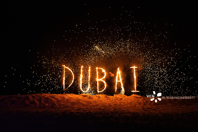 用火在沙漠中创造的迪拜字样图片素材