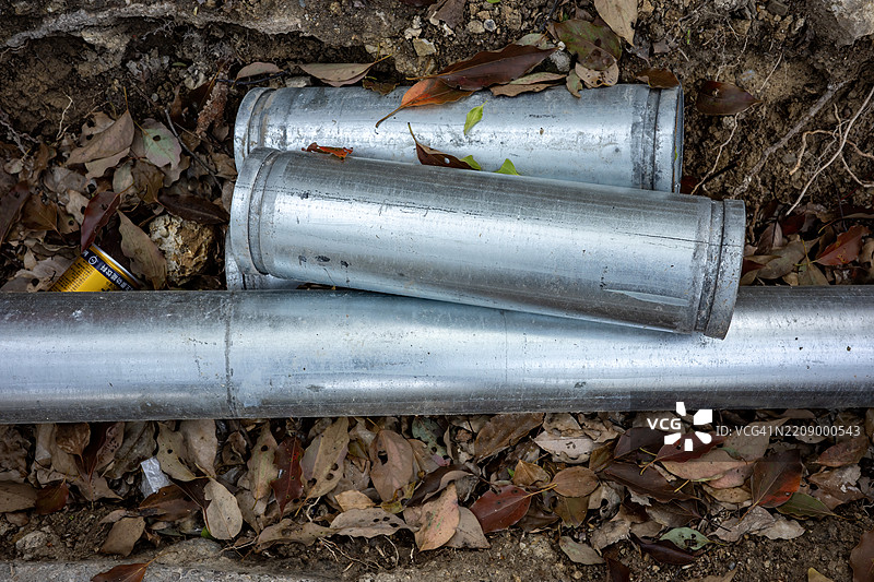 废弃的镀锌管静静地躺在干燥的森林残骸中图片素材