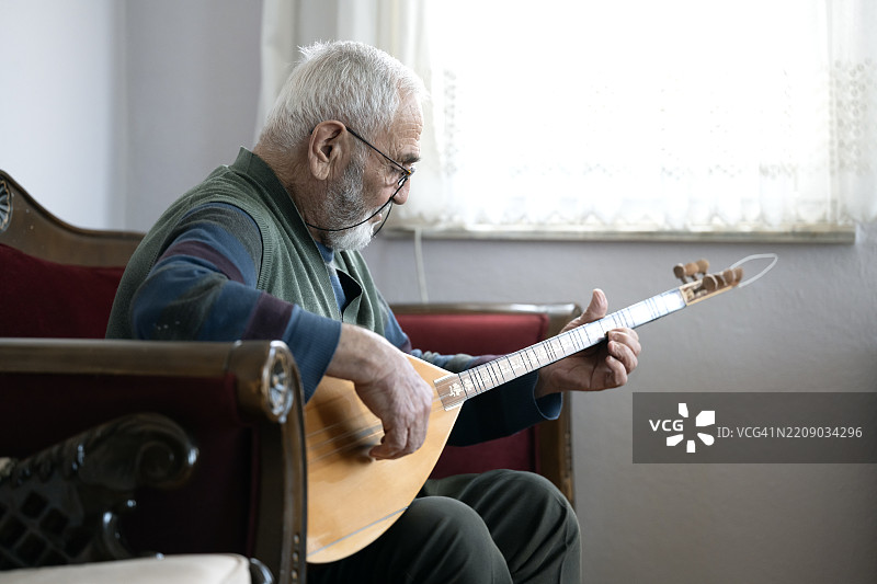 一位老年人演奏土耳其弦乐器巴格拉玛图片素材