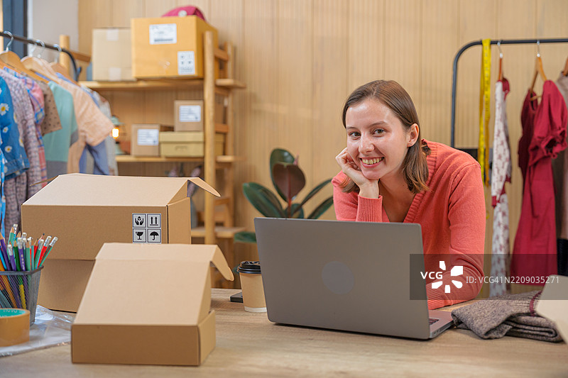 女性小企业主使用笔记本电脑查看客户订单，她正在经营一家在线商店。图片素材