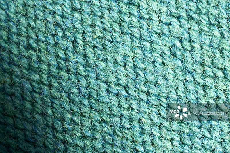 温暖舒适的青绿色针织羊毛面料纹理背景，清晰可见的单个线头和针脚，适合冬季项目。图片素材