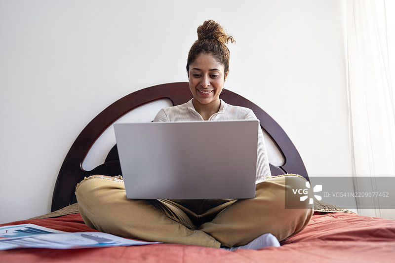 女人在卧室的阳台上工作。图片素材