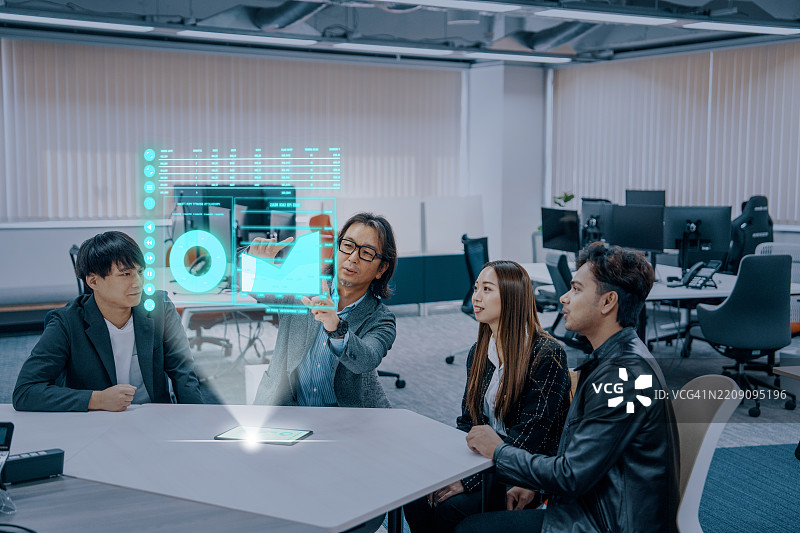 在公司办公室中使用未来派全息界面的商务会议。图片素材