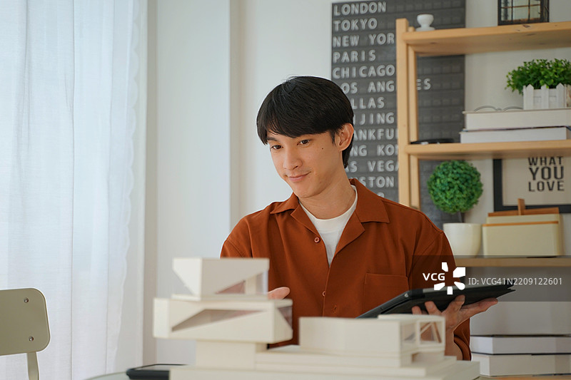 这个男人正在制作建筑模型。图片素材