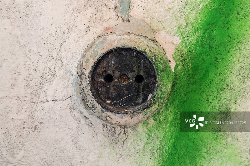 废弃建筑中旧墙上的老电源插座图片素材