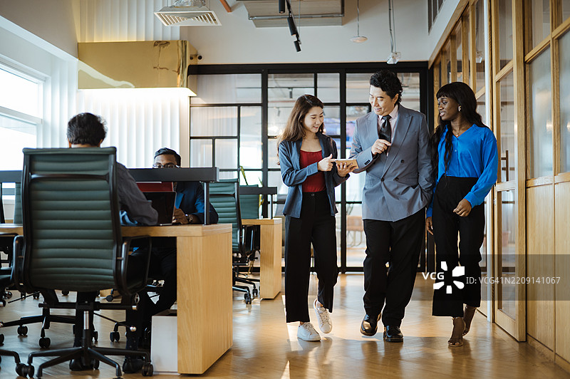 Business Leaders in Corridor Having Informal Meeting on the Go.图片素材