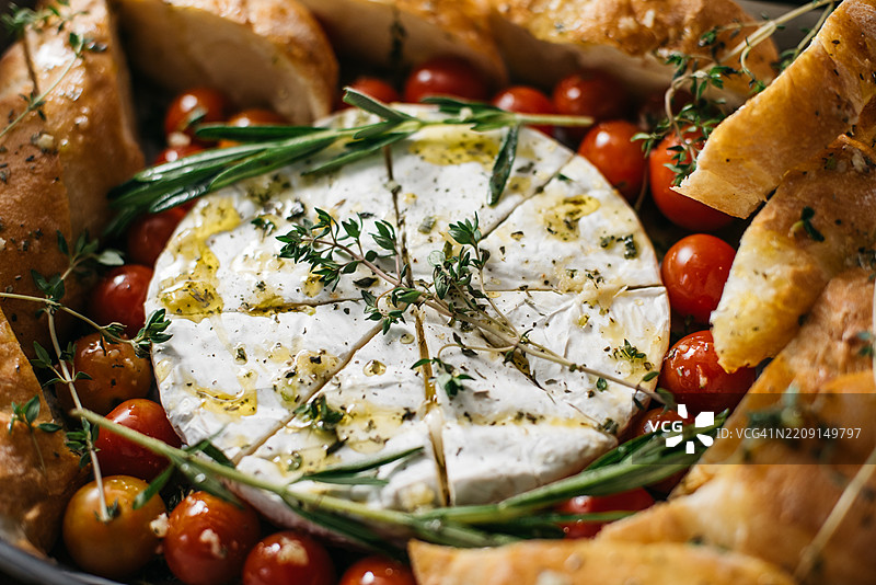 烤卡门贝尔奶酪配番茄和香草图片素材