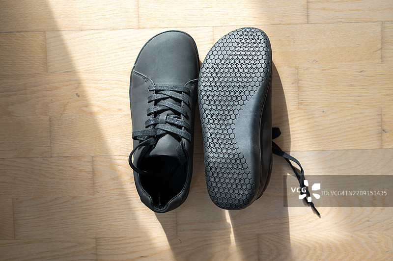 黑色系带赤足鞋放在地板上图片素材