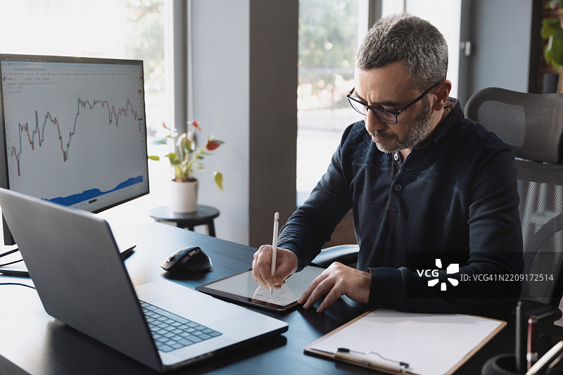 在办公室使用TradingView处理股票市场交易数据的男士图片素材