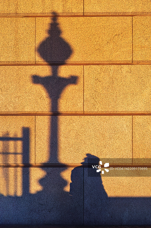 伦敦桥附近日落时分的女人和路灯的影子，英国伦敦图片素材