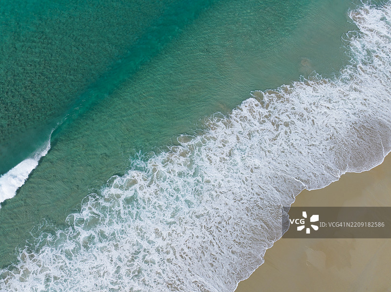 海滩，清澈的蓝色海洋和从上方俯瞰的波浪图片素材