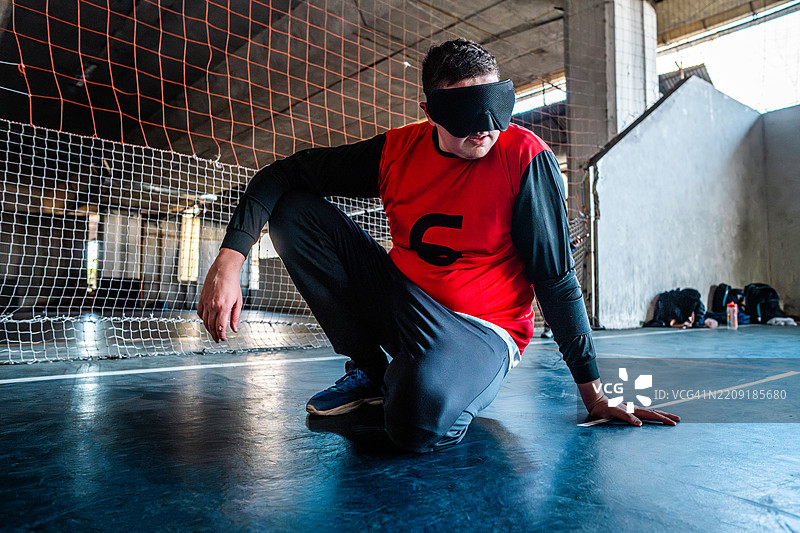 年轻的视障男子在运动场上打手球图片素材