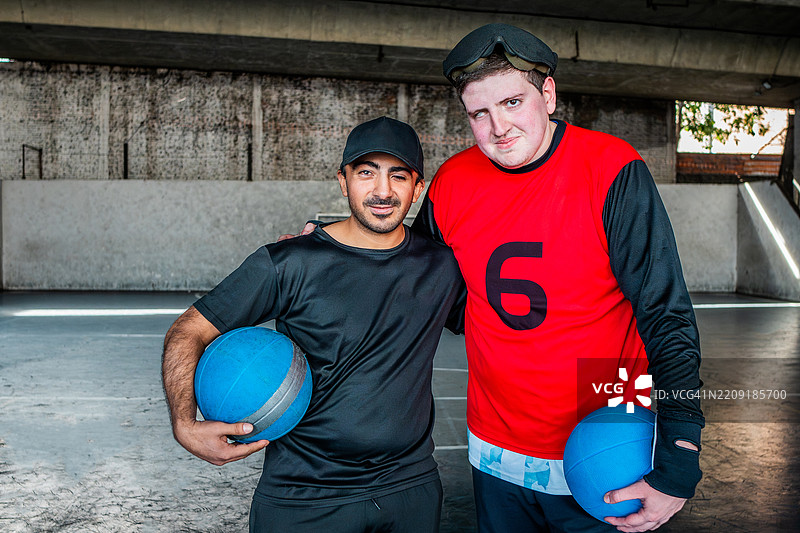 视力受损的手球运动员在场地上与教练拥抱的肖像图片素材