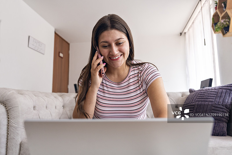 在家中使用笔记本电脑工作的男人。图片素材