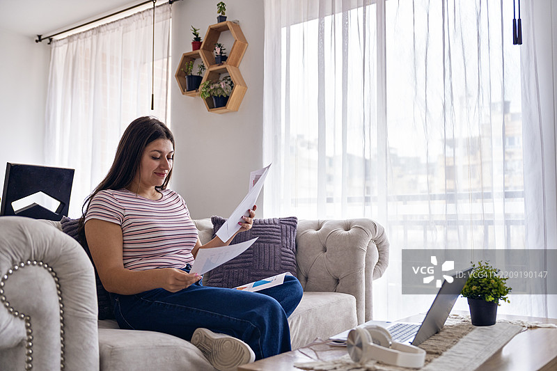 在家中使用笔记本电脑工作的男人。图片素材