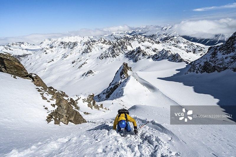 冬季登山者手持冰镐和冰爪，攀登陡峭的雪地，前往Piz Kesch或Piz d'Es-cha，俯瞰Vadret da Porchabella冰川的山脉全景，阿尔布拉阿尔卑斯山，瑞士拉赫蒂安阿尔卑斯山，格劳宾登州，瑞士东部，欧洲图片素材