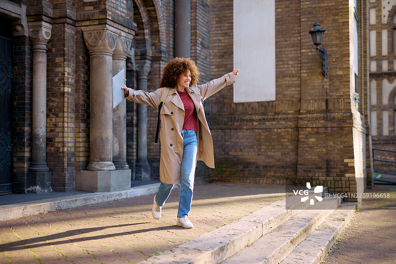快乐的学生在大学建筑外庆祝成功图片素材