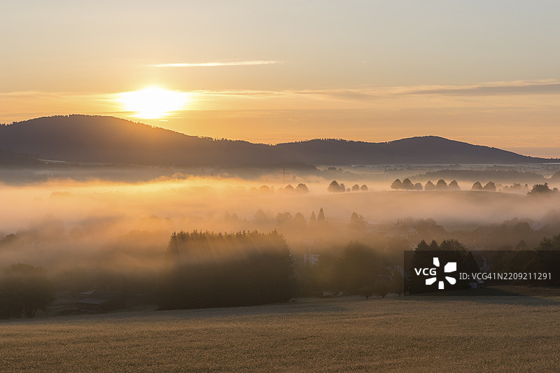 德国萨克森州希尔吉斯瓦尔德-基尔绍的卡伦贝格俯瞰的奥伯劳西茨山地，晨光中的雾气弥漫。图片素材