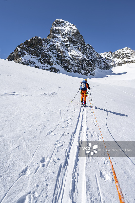 滑雪登山者与绳索，绳索团队在瓦德雷特·达·波尔查贝拉冰川上攀登基什峰，冬季山地风景，阿尔卑斯滑雪之旅，布伦特高路线，阿尔布拉阿尔卑斯，瑞士拉赫蒂安阿尔卑斯，格劳宾登，瑞士东部，瑞士。图片素材
