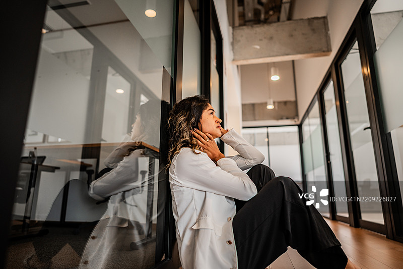 担忧的女商人在办公室坐在地上图片素材