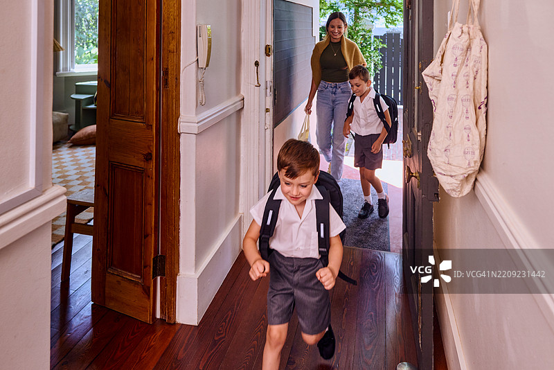母亲带着孩子们离家去上学图片素材