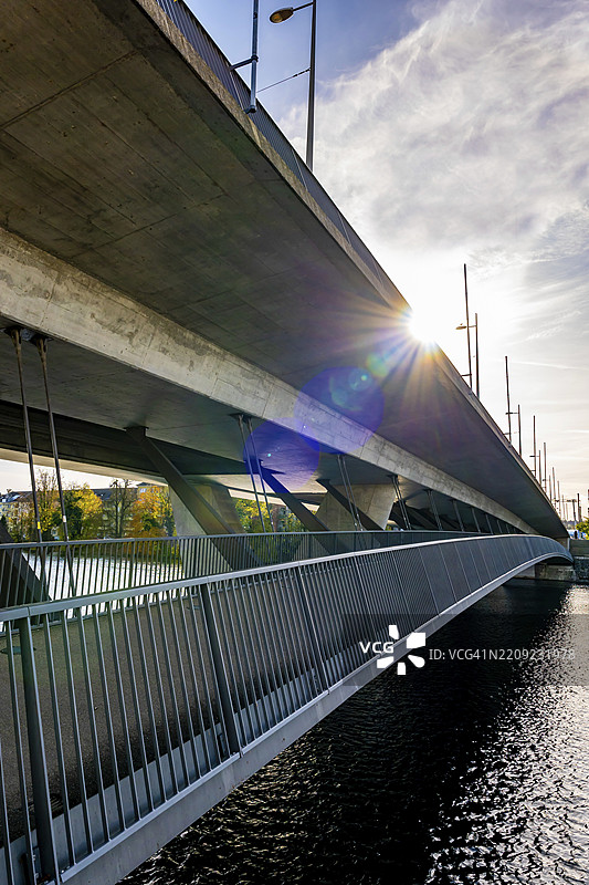 现代桥梁和人行道横跨阿尔河，阳光明媚的秋日阳光洒在瑞士索洛图恩，索洛图恩州。图片素材