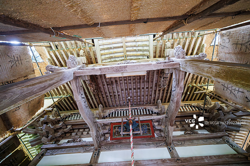 一个大型的钟,用于在参拜神社时敲响。宏伟的主殿位于一片杉树林中。它被稻草和布料覆盖,以保护木材免受雪的侵害。捐赠者的签名也写在上面。图片素材