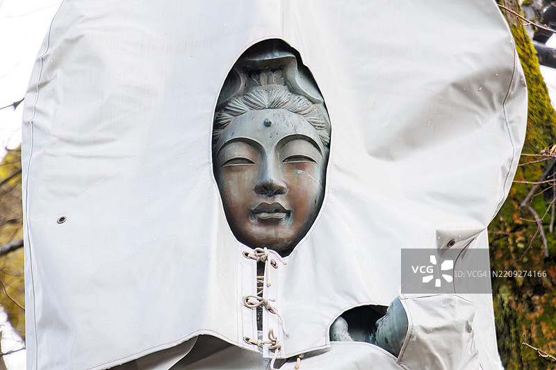 一座大型观音雕像，覆盖着塑料罩以保护其免受雪的侵袭。寺庙位于车站前面，周围有许多古老的地藏菩萨石像和其他雕像。任何人都可以自由参观这座寺庙。图片素材