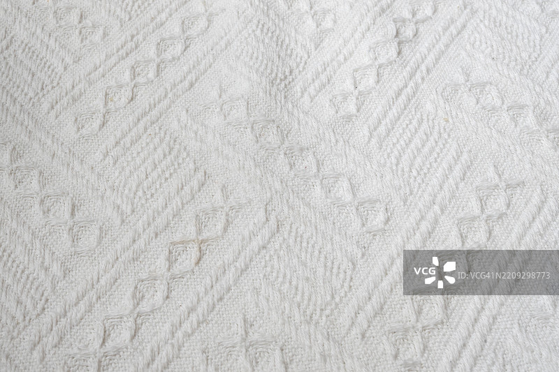 带有方形和菱形图案的白色毛毯图片素材
