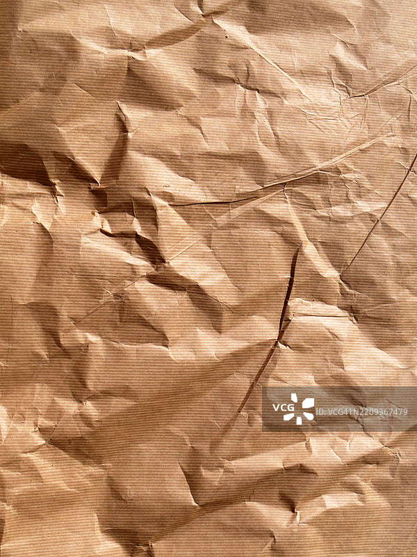 条纹状、揉皱的棕色纸张背景。粗糙的纹理。阳光。自然色彩。比利时布鲁塞尔。图片素材