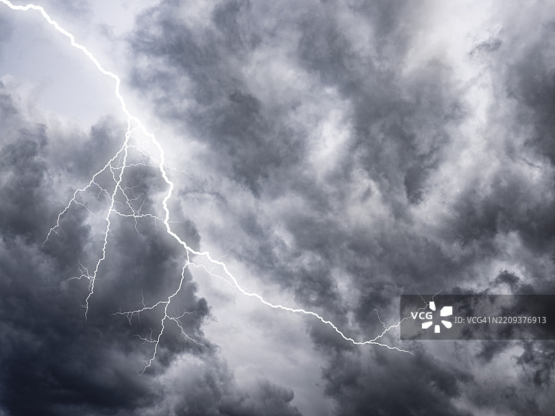 灰色暴风雨的天空，伴随着闪电和雨水。图片素材
