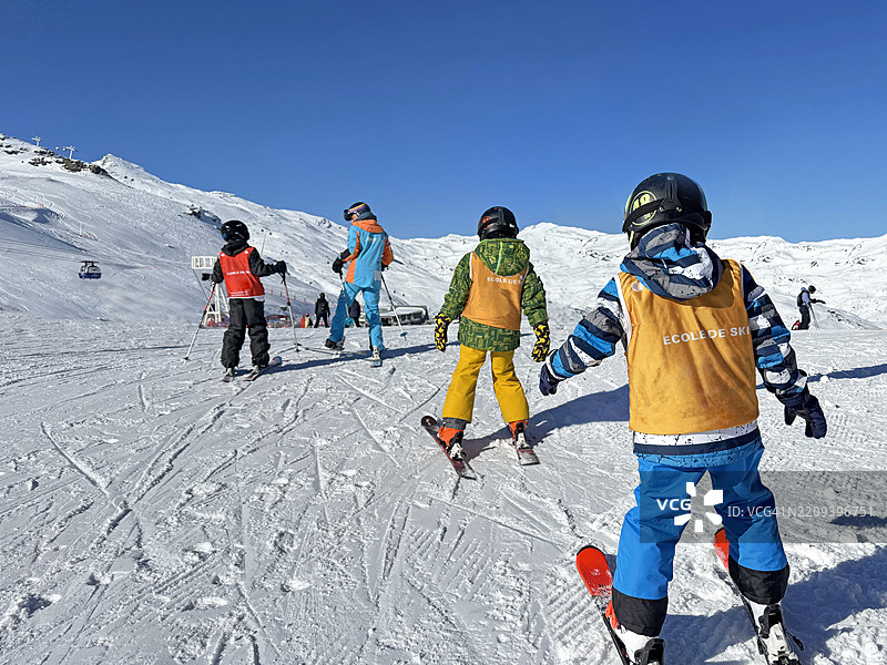 儿童和教练在法国阿尔卑斯山参加滑雪学校图片素材