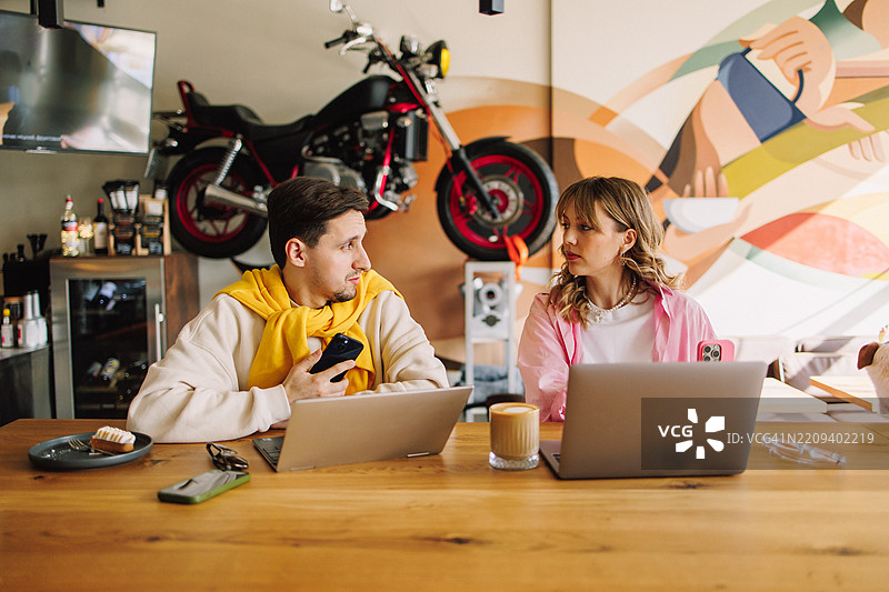 在现代咖啡馆合作的自由职业情侣图片素材