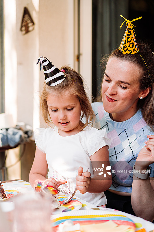 母女在户外派对上庆祝，周围装饰着节日装饰品图片素材