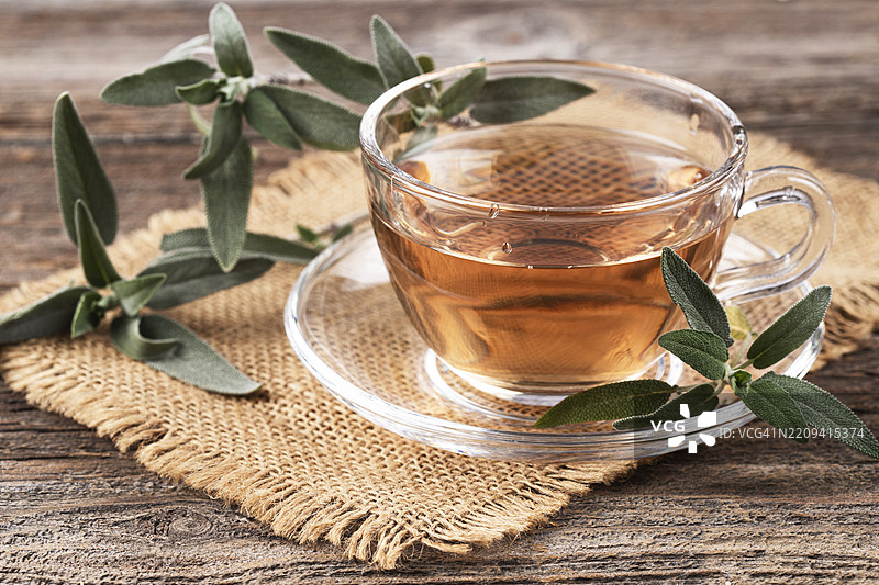 玻璃杯装的鼠尾草茶，配有鼠尾草叶图片素材