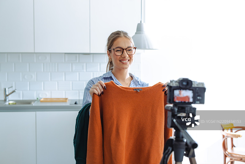 年轻女性在家中录制关于服装的视频博客图片素材