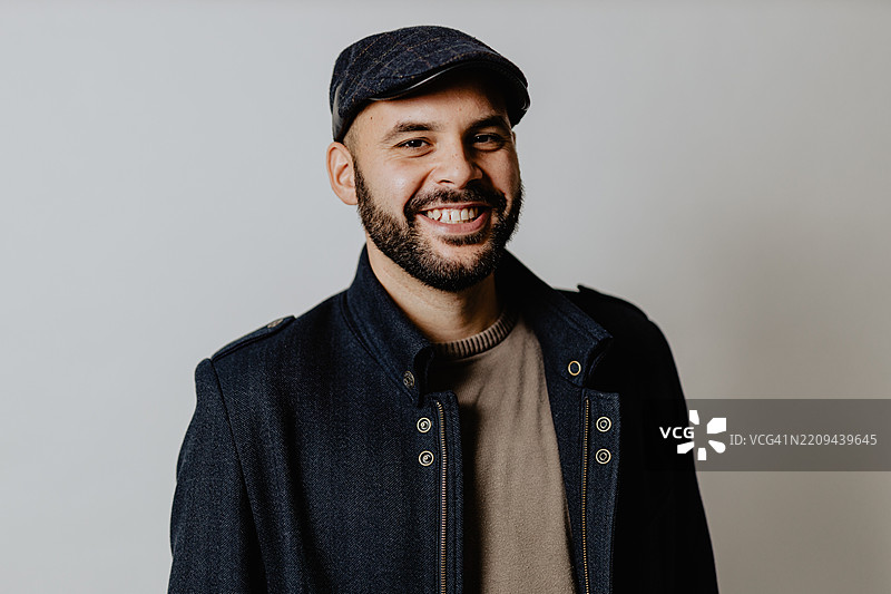 自信的男人在白色摄影棚背景前摆姿势图片素材