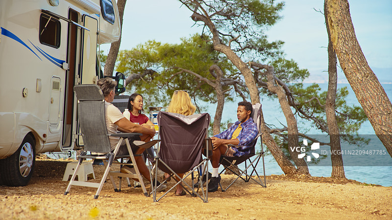 多元化的朋友们在阳光明媚的海边露营地放松图片素材