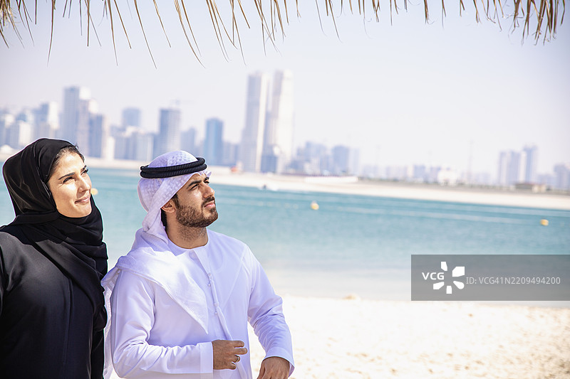 快乐的阿拉伯夫妇在海滩上图片素材