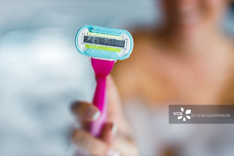 女人手中的剃刀特写。图片素材