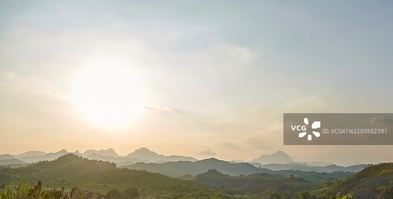 日出为层叠的山脉洒下温暖的光辉。图片素材