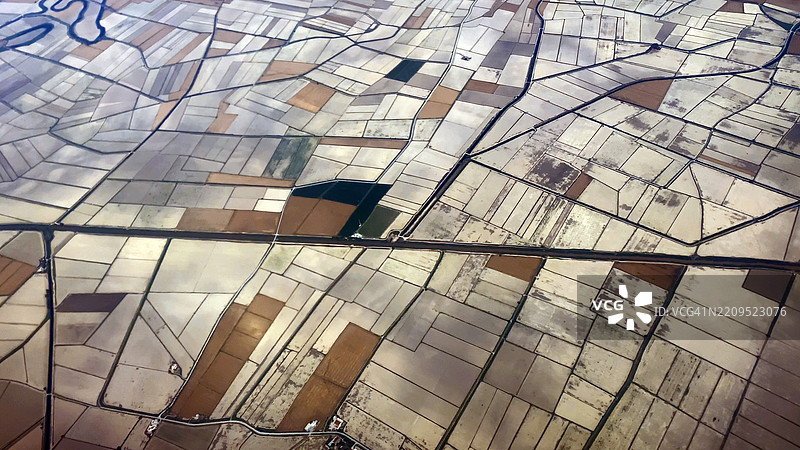 清晰的农业农田鸟瞰图，带有灌溉渠、山脉和海洋 – 从飞机窗户俯瞰田野、乡村风光和沿海平原的美丽视角图片素材